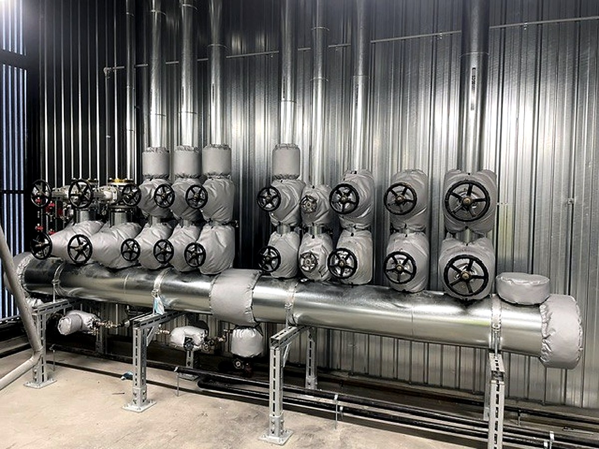 Thermal jackets fitted to a row of gate valve assemblies along a large industrial pipe run